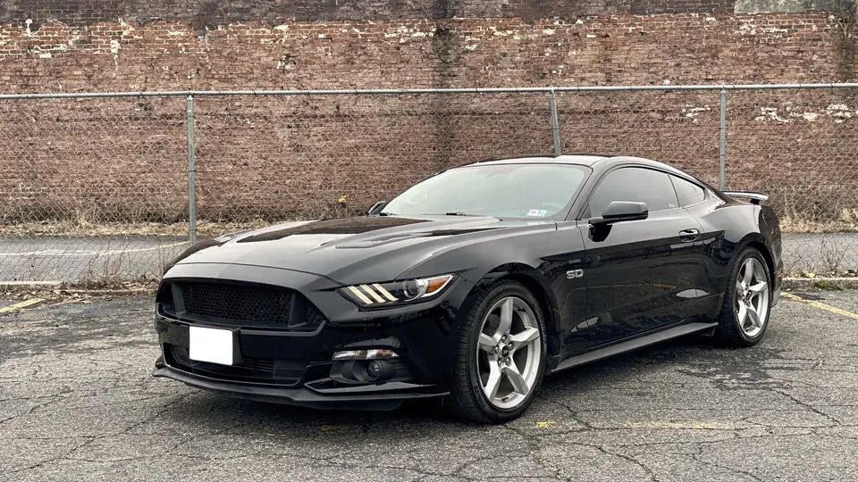 Black Ford Mustang GT coupe parked on the lot (AI placeholder photo)